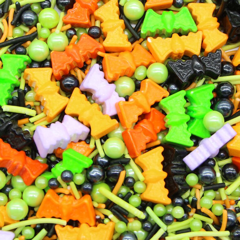 Spooky Halloween sprinkle mix with orange, green, black and purple bat shapes and pearls