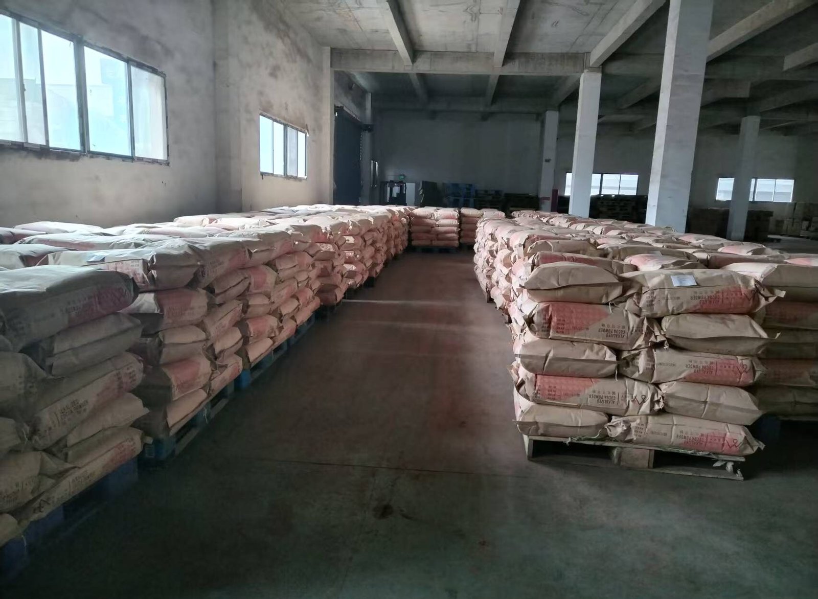 Warehouse of imported cocoa raw material sacks on pallets