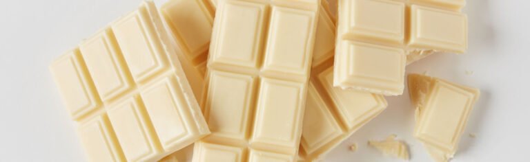 Broken white chocolate bars on a white surface